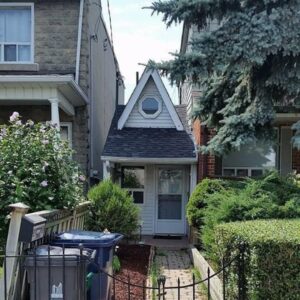 photo of tiny house squished in between two normal houses