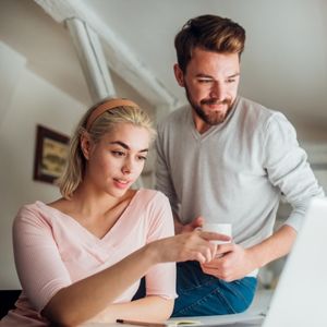 A couple at home looking at a computer together